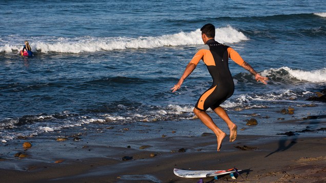 O surfista Gabriel Medina se aquece antes de entrar no mar, na Califórnia