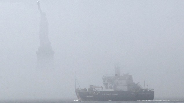 Navio da Guarda Costeira passa em frente à Estátua da Liberdade envolta em nevoeiro