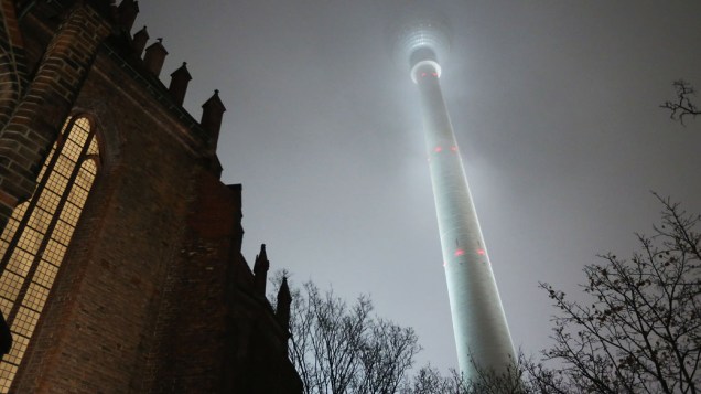 Igreja Marienkirche ao lado de uma torre de transmissão em uma noite de nevoeiro em Alexanderplatz, Berlim 