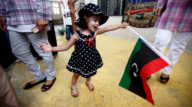 Garota carrega a bandeira líbia em escola primária na cidade de Trípoli