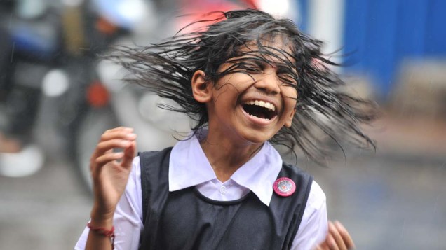 Garota indiana brinca na chuva em Hyderabad