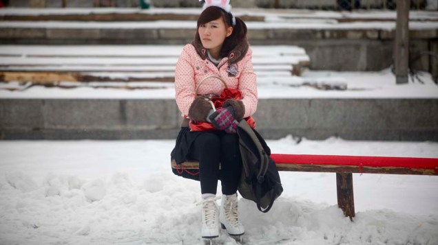 Garota chinesa descansa sobre um lago congelado em Pequim
