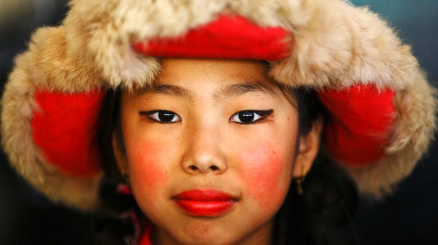 Menina tibetana vestida de trajes tradicionais durante comemoração do aniversário de 77 anos do líder espiritual tibetano, Dalai Lama