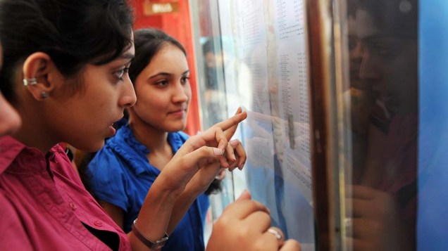 Estudantes indianas conferem resultado de provas em colégio na cidade de Nova Délhi