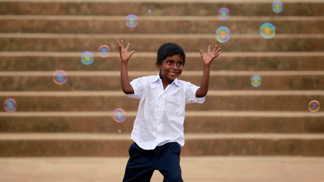 Garoto brinca com bolas de sabão em Colombo, Sri Lanka