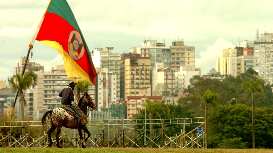 gaúcho com roupa típica, montado a cavalo, observa o centro de Porto Alegre