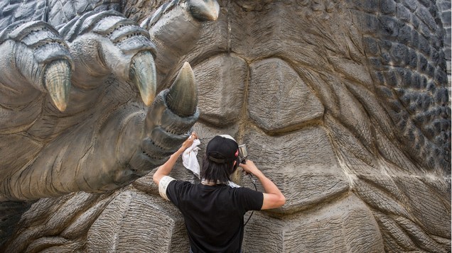 O artista plástico, Tetsuo Hayashi, dá os retoques finais para o corpo de uma réplica de 6,6 metros do famoso Godzilla, no centro de Tóquio, Japão. O projeto está em colaboração com o lançamento da versão cinematográfica de Hollywood, Godzilla, no país