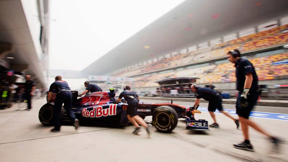 Engenheiros empurram o carro do piloto reserva Daniel Ricciardo no Circuito Internacional de Xangai, na China