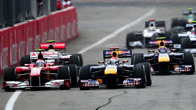 O piloto alemão Sebastian Vettel (centro) pressiona a Ferrari de Fernando Alonso contra a parede, no início do GP de Fórmula 1 da Alemanha