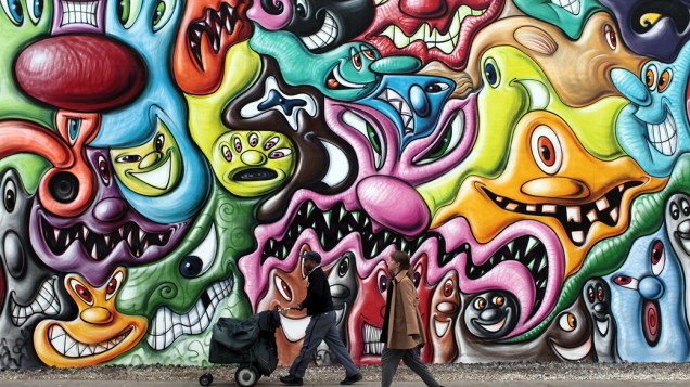 Pedrestes passam por grafite de Kenny Scharf, em Nova York