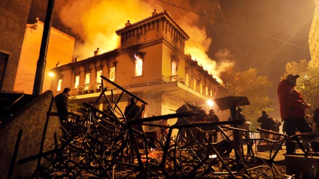 Incêndio em uma loja durante confrontos entre manifestantes e a polícia perto do Parlamento grego em Atenas, 12/02/2012