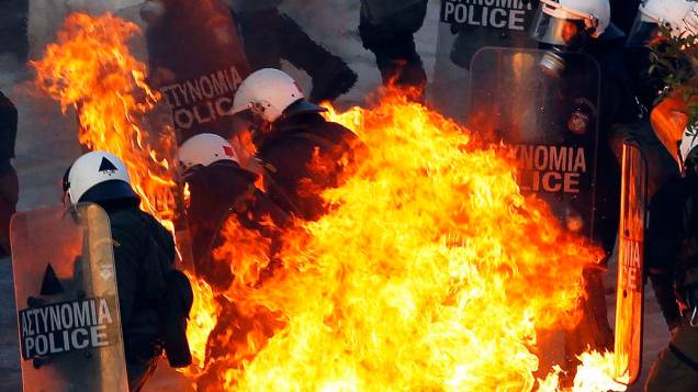 Policiais atingidos por coquetel molotov durante confrontos em Atenas, 12/02/2012