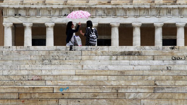 Poucos turistas em frente do Parlamento grego durante uma chuva na cidade de Atenas. Parlamento da Grécia deve ser dissolvido para que novas eleições podem ser realizadas 17 de junho