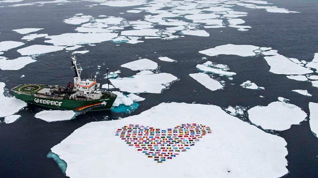 Bandeiras dos 193 países que integram a ONU são colocadas na neve em frente navio Sunrise, do Greenpeace. A organização aproveitou a expedição "Artic Sunrise" para apelar à ONU por medidas contra o degelo do Ártico