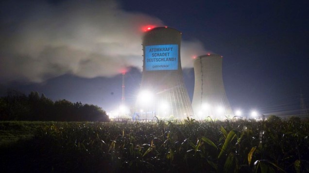Ativistas do Greenpeace projetam os dizeres “A energia nuclear prejudica a Alemanha” em uma torre de resfriamento da usina nuclear de Grafenrheinfeld, Alemanha