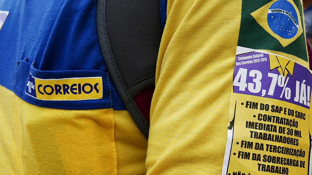 Trabalhador dos Correios protesta em frente à sede da estatal, em Brasília
