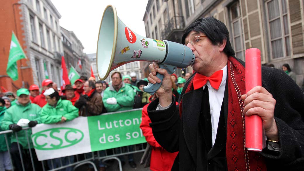 Homem vestido como o primeiro ministro da Bélgica, Elio Di Rupo, durante ação de greve em frente a casa de Rupo