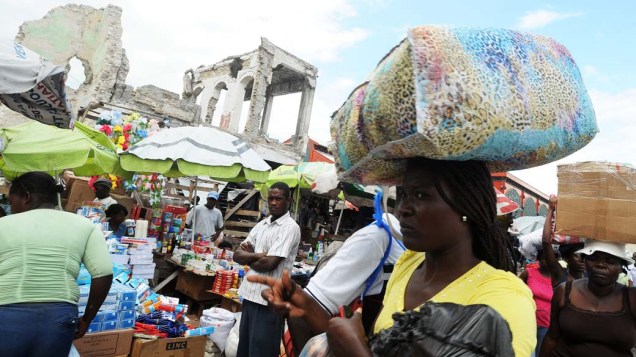 Mulher carrega pacote na cabeça durante feira de produtos em Porto Princípe no Haiti, em 09 de janeiro de 2012