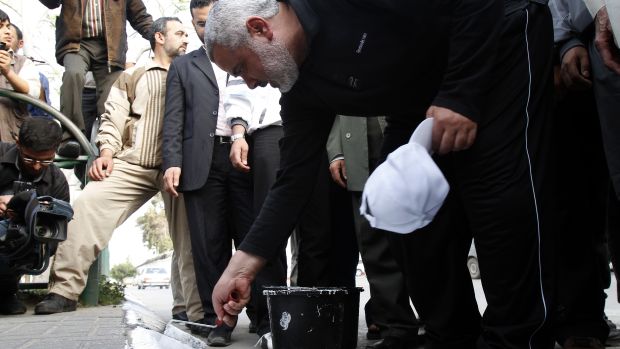 Líder do Hamas pinta calçada em celebração palestina um dia antes da assinatura do acordo no Cairo