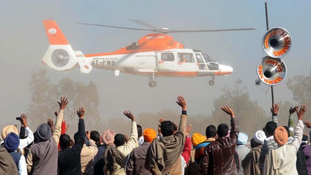 Partidários da dirigente do partido no poder na Índia, Sonia Gandhi, acenam para helicóptero durante comício em Punjab