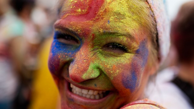 Mulher com o rosto colorido em pó durante o Festival de Holi, em Berlim, Alemanha
