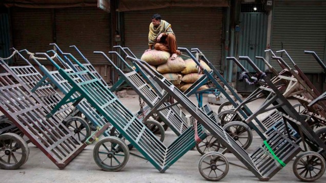 Homem aguarda abertura de mercado em Lahore, Paquistão