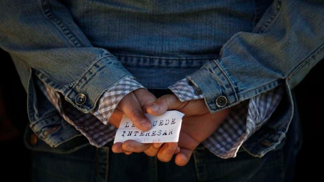 Homem com folheto escrito “Você pode se interessar”, em fila de um centro para empregos na cidade de Málaga, Espanha