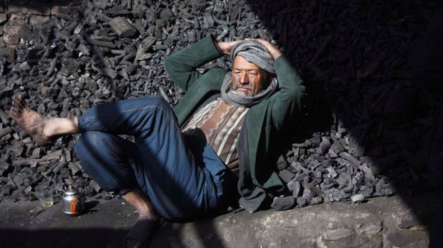 Vendedor de carvão descansa durante trabalho em Cabul, no Afeganistão