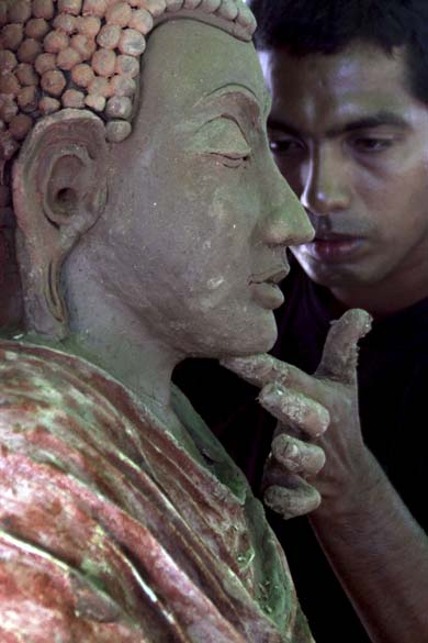 Em Colombo, Sri Lanka, membro do exército cingalês retoca estátua de Buda para as celebrações do Festival de Wesak