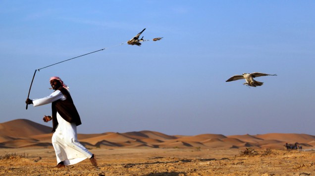 Homem atrai falcão durante competição no Festival Internacional de Falcoaria nos Emirados Árabes