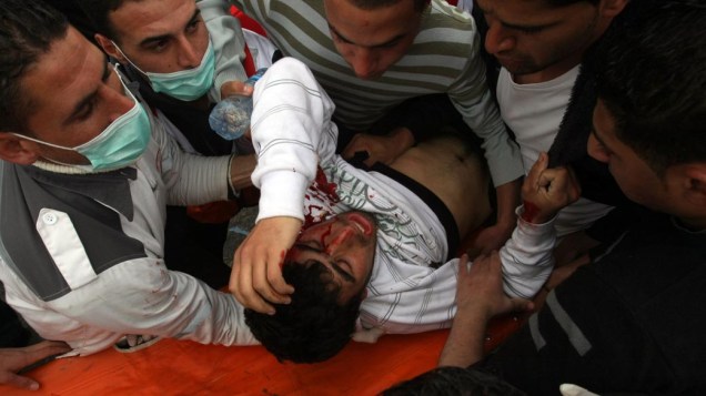 Manifestante palestino atingido por gás lacrimogêneo disparado por soldados israelenses durante protestos na barreira de separação israelense no assentamento judaíco da Cisjordânia no "Dia da Terra"