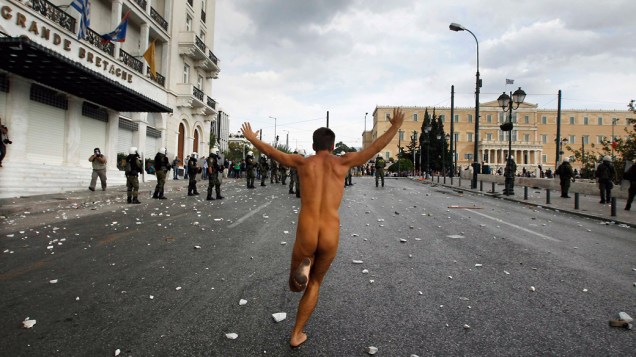 Manifestante nu na frente do edifício do Parlamento na Praça Syntagma, em Atenas, durante protesto contra a visita da chanceler da Alemanha, Angela Merkel