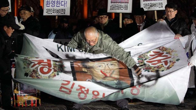 Em Seul, manifestantes rasgam retrato do falecido Kim Jong-Il durante um comício para celebrar a morte do líder norte-coreano, Coreia do Sul