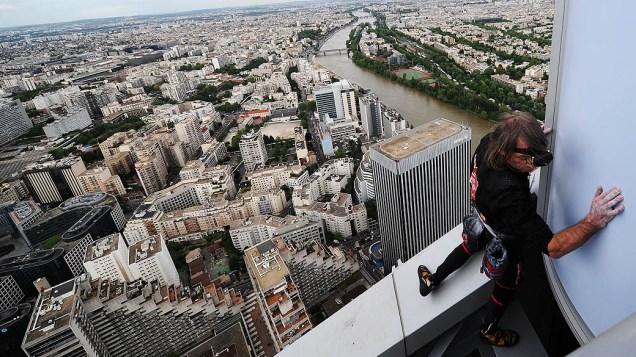 O alpinista urbano Alain Robert, conhecido como o "homem-aranha francês", escala o edifício Fist de 231 metros de altura; localizado no bairro financeiro de Paris, La Défense, o alpinista chegou no topo do arranha-céu em menos de uma hora