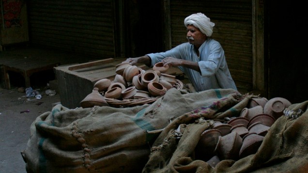 Vendedor arruma potes em mercado de Faisalabad, no Paquistão