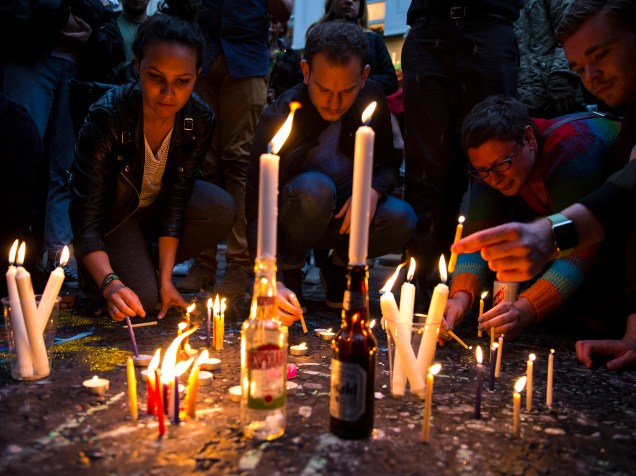 Pessoas acendem velas em homenagem às vítimas de Orlando, na rua Old Compton em Londres, Inglaterra