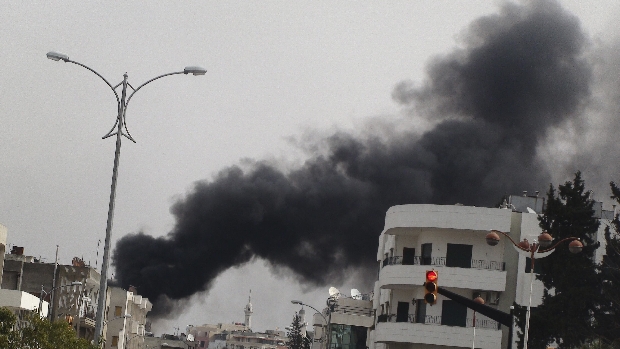 Fumaça negra é vista em bairro de Homs bombardeado por forças de Assad