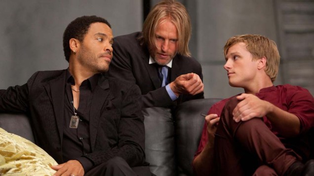 Cinna (Lenny Kravitzt), à esquerda, é o estilista pessoal de Katniss (Jennifer Lawrence); já Haymitch Abernathy (Woody Harrelson), ao centro, é o mentor dela e de Peeta Mellark (Josh Hutcherson), à direita