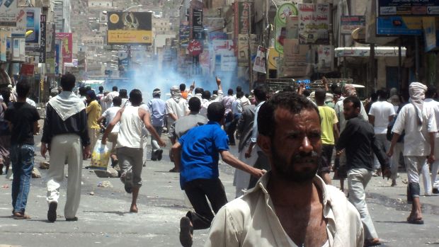 Iemenitas fogem de bombas de gás lacrimogêneo em Taiz
