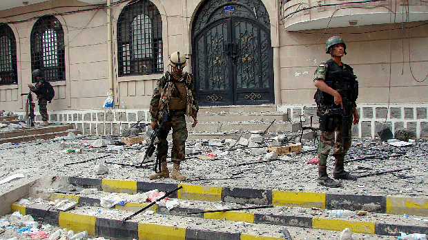 Forças iemenitas observam destruição em local onde confrontos com opositores ocorreramm, em Sanaa