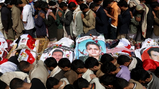 População reza durante o enterro dos corpos de ativistas mortos durante o massacre em Sanaa