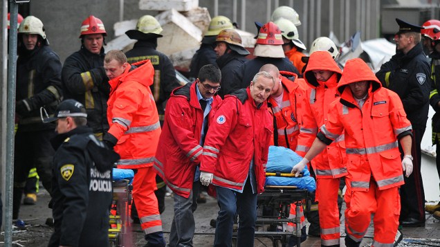 Equipes de resgate carregam corpo de vítima do desabamento do teto do supermercado Maxima em Riga, um subúrbio da capital da Letônia