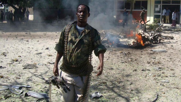 Policial caminha por local onde um carro bomba explodiu ferindo dois policiais em Mogadishu, Somália