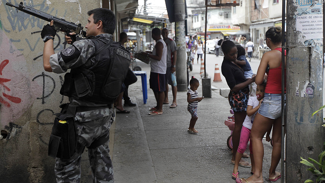 Policial em posição durante operação no complexo da Maré, no Rio de Janeiro