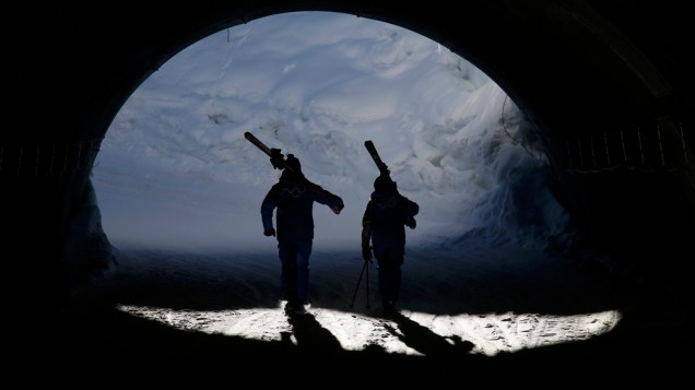 Voluntários carregam esquis nos treinos para os  Jogos Olímpicos de Inverno de Sochi, na Rússia