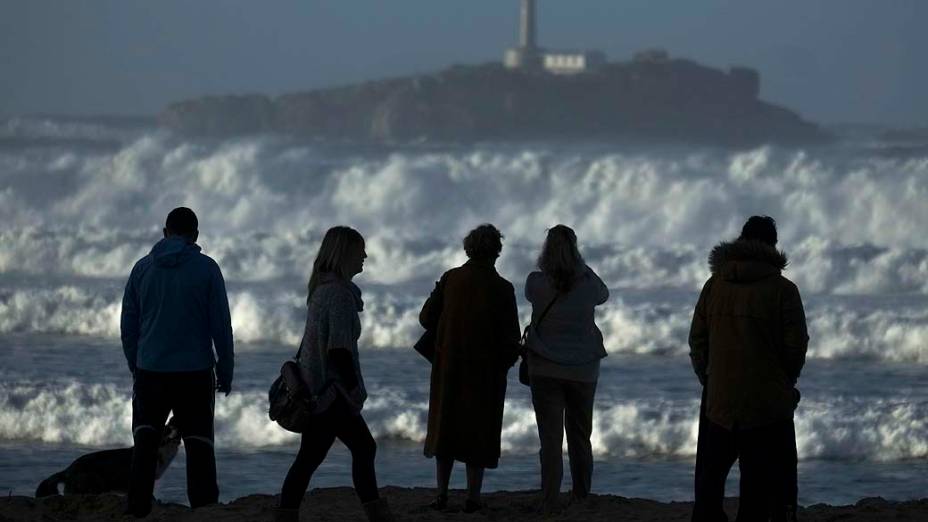 Turistas assistem ondas atingirem encosta, na Espanha