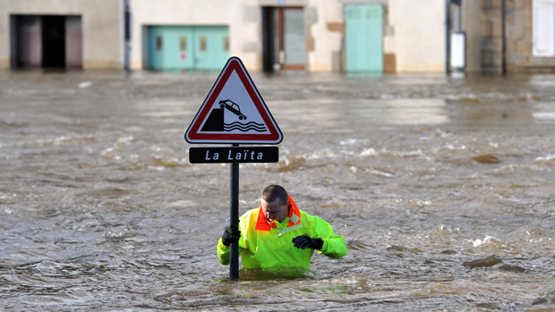 Bombeiro verifica uma placa de sinalização em uma rua inundada pelo rio costeiro Laita no centro da cidade de Quimperle, oeste da França