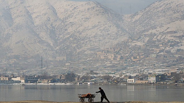 Homem empurra carrinho em lago, no Afeganistão, nesta segunda-feira (10)