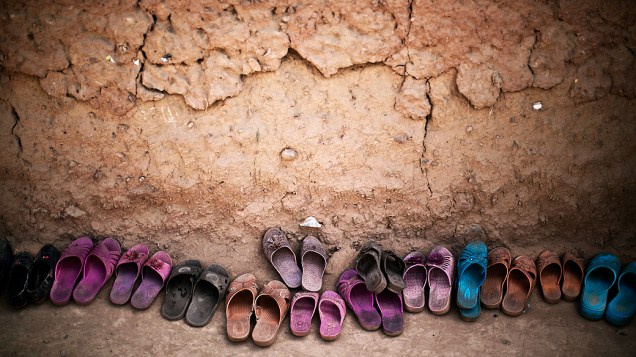 Sapatos pertencentes a crianças refugiadas afegãs são deixados do lado de fora de uma mesquita durante um evento por ocasião do Dia Mundial das Nações Unidas de justiça social, em uma escola improvisada na periferia de Islamabad, no Paquistão