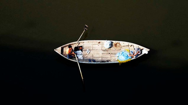 Pescador é fotografado nas águas sagradas do rio Ganes, em Allahabad, na Índia